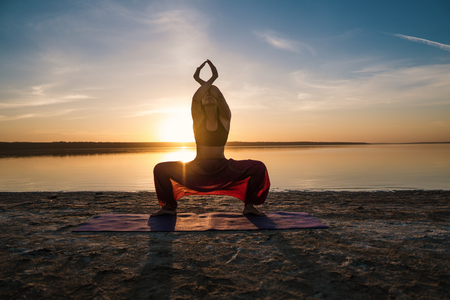 yoga woman on the beach at sunset.の写真素材