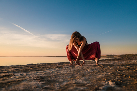 yoga woman on the beach at sunset.の写真素材