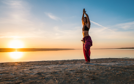 yoga woman on the beach at sunset.の写真素材