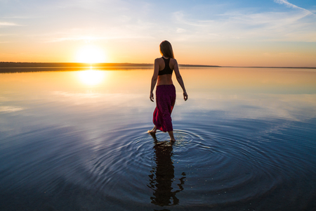 Silhouette yoga woman on the beach at sunset.の写真素材