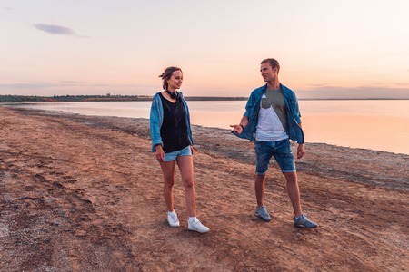 oung couple on the beach walking togetherの写真素材
