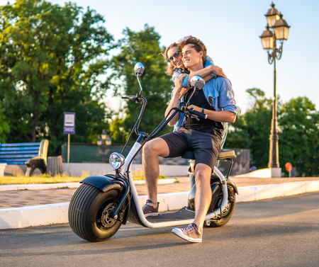 Lovely young couple dating with electric bike.の写真素材