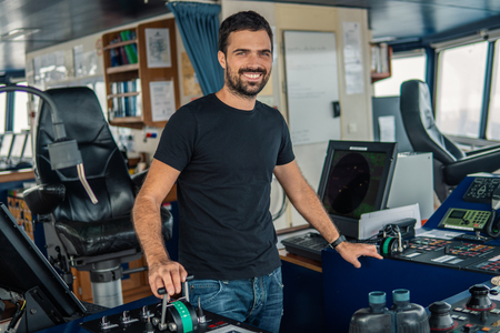 Marine navigational officer is maneuvering ship or vessel