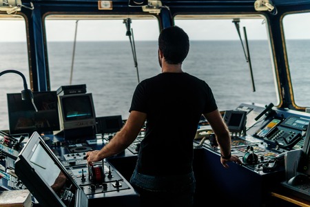 Marine navigational officer is maneuvering ship or vessel