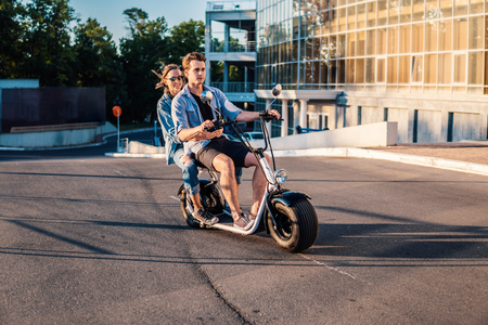 Lovely young happy couple driving electric bikeの写真素材