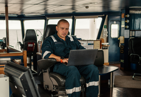 Marine navigational officer is using laptop or notebook at seaの写真素材