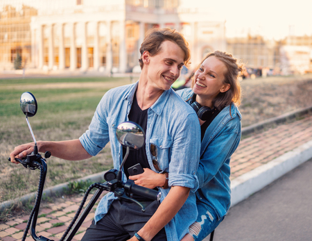 Lovely young couple driving electric bike during summerの写真素材