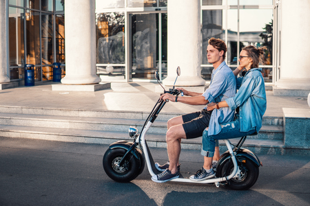 Lovely young happy couple driving electric bikeの写真素材