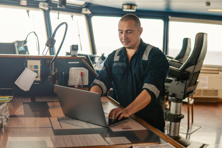 Marine navigational officer is using laptop or notebook at seaの写真素材