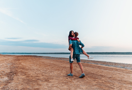 oung couple on the beach walking togetherの写真素材