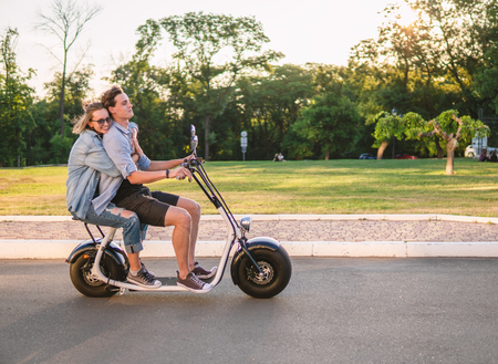 Lovely young happy couple driving electric bikeの写真素材