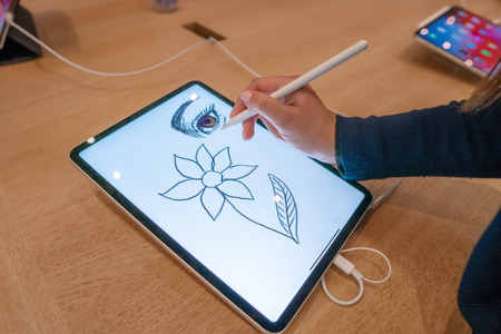 graphic designer girl drawing sketch on digital tablet screen with stylus pencilの写真素材