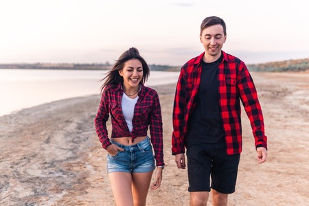 oung couple on the beach walking togetherの写真素材