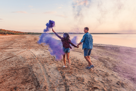 young couple running with hand flare or fuseeの写真素材