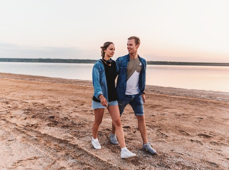 oung couple on the beach walking togetherの写真素材