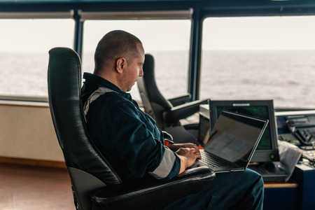Marine navigational officer is using laptop or notebook at seaの写真素材