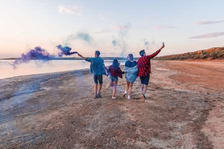 young friends running with hand flare or fuseeの写真素材
