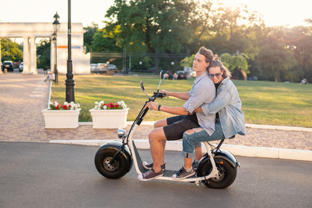 Lovely young happy couple driving electric bikeの写真素材