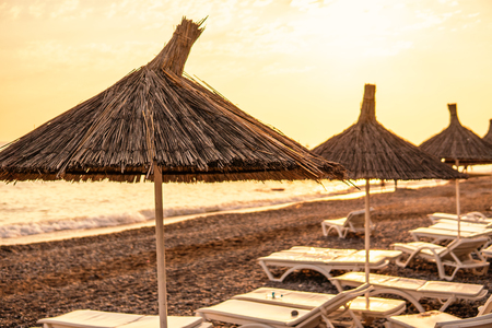 tropical umbrellas on a island beach. Blue ocean on backgroundの写真素材