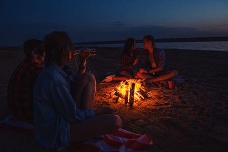 young friends have picnic with bonfire on the beachの写真素材