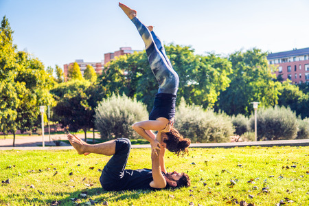Beautiful couple practicing acro yoga in the morning