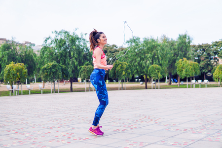 Fit beautiful woman with jumping rope in a parkの写真素材