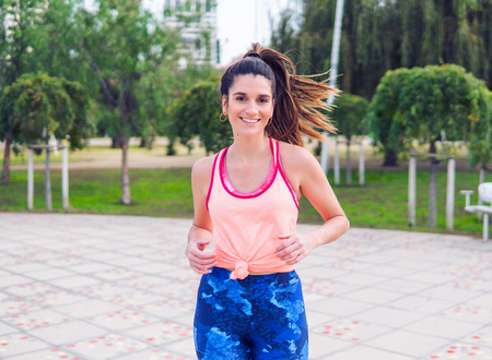 Young beautiful fit woman is running in the parkの写真素材