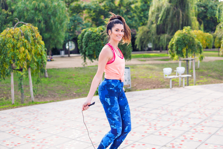 Fit beautiful woman with jumping rope in a parkの写真素材