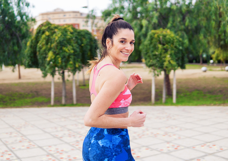 Young beautiful fit woman is running in the parkの写真素材