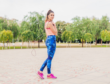 Fit beautiful woman with jumping rope in a parkの写真素材