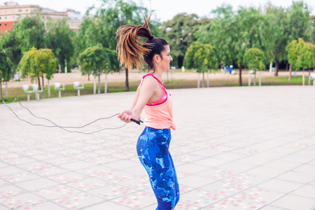Fit beautiful woman with jumping rope in a parkの写真素材