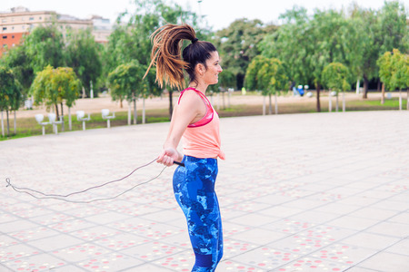 Fit beautiful woman with jumping rope in a parkの写真素材