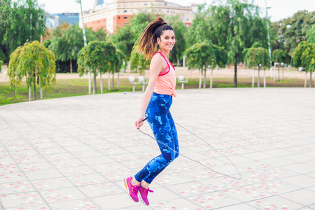 Fit beautiful woman with jumping rope in a parkの写真素材