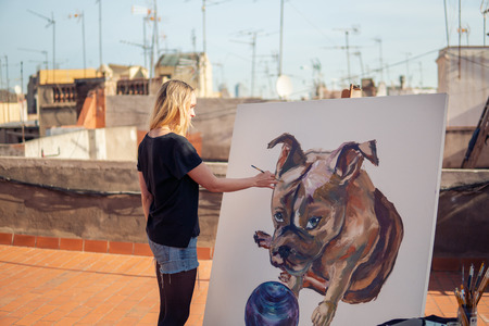 Young woman paint artist drawing at home roofの写真素材
