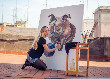 Young woman paint artist drawing at home roofの写真素材