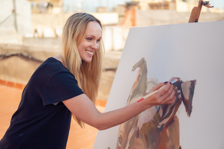 Young woman paint artist drawing at home roofの写真素材