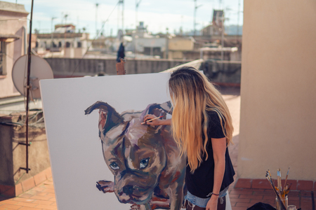 Young woman paint artist drawing at home roofの写真素材