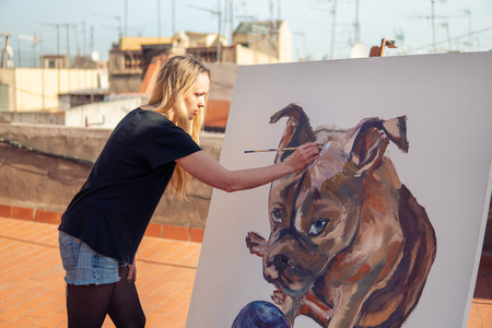 Young woman paint artist drawing at home roofの写真素材