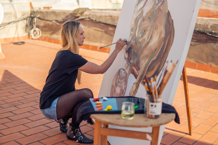 Young woman paint artist drawing at home roofの写真素材