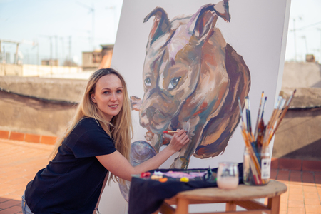 Young woman paint artist drawing at home roofの写真素材