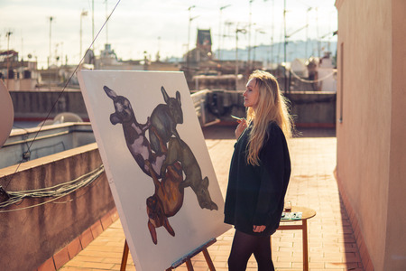 Young woman paint artist drawing at home roofの写真素材