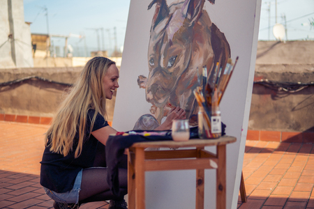 Young woman paint artist drawing at home roofの写真素材