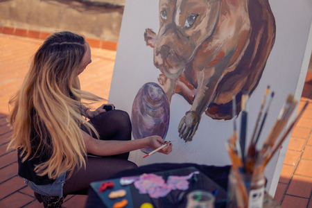 Young woman paint artist drawing at home roofの写真素材