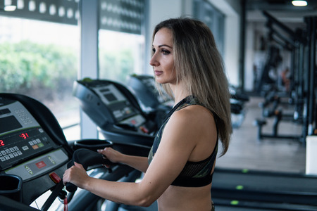 Young fit woman doing running exercise in gymの写真素材