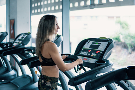 Young fit woman doing running exercise in gymの写真素材