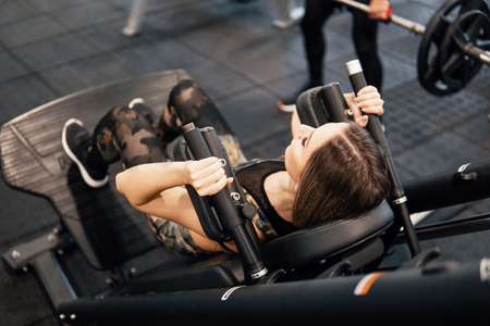 Young fit woman doing workout exercise in gymの写真素材