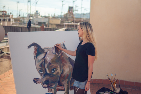 Young woman paint artist drawing at home roofの写真素材