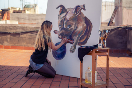 Young woman paint artist drawing at home roofの写真素材