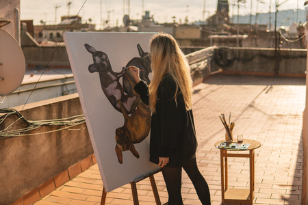 Young woman paint artist drawing at home roofの写真素材