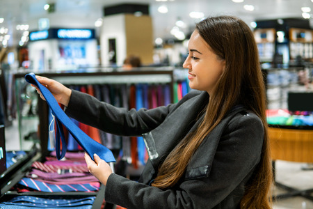 woman finding a gift tie in a store supermarketの写真素材